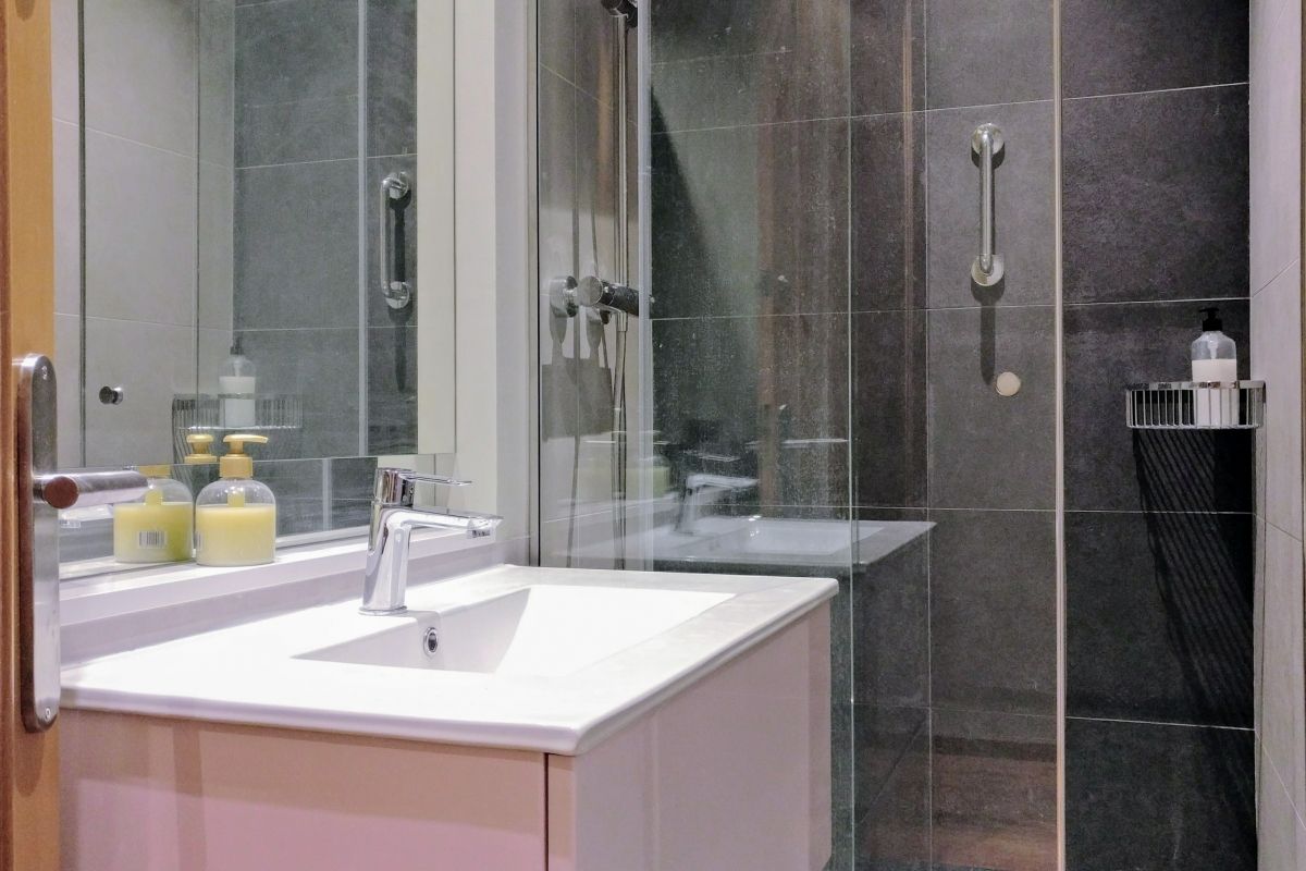 general view of one of the bathrooms with shower cabin and washbasin in the Dandi apartment for rent in Barcelona