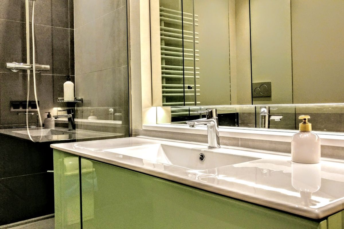 ensuite master bath with a jetted bathtub and a separated shower cabin with rainshower system in this luxury apartment for rent short term in Barcelona