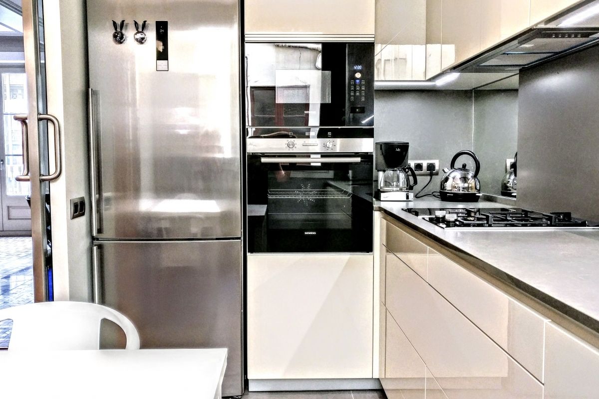 sleek modern kitchen with stainless steel apliances and mirror splashbacks