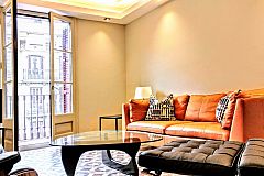 signature leather furniture and sofa at the Dandi luxury apartment for short term rentals in Barcelona. You will relax sitting in the Barcelona chair and ottoman and the Noguchi coffe table that rounds the scene.