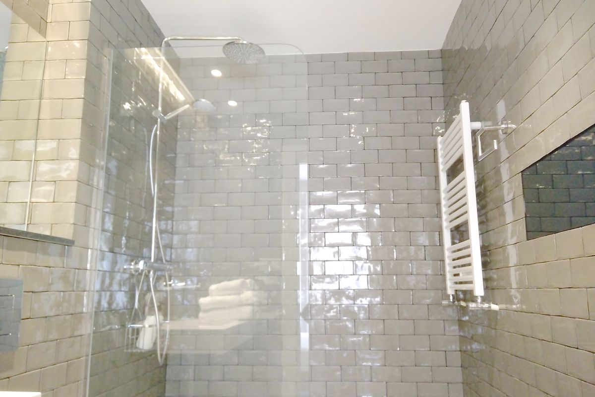 ensuite bathroom with rainfall shower head in this pentouse for rent in Barcelona  