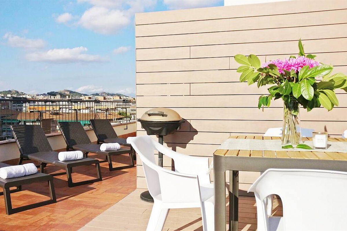 deck chairs to sunbathe, night ilumination, outdoor shower and BBQ all waiting for you in this private, panoramic terrace in this rental properties in Barcelona