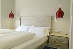 dramatic red hanging lamps next to the headboard in the master bedroom