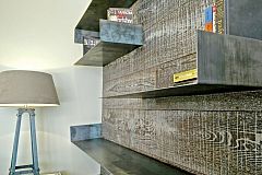 the superb platform flooring crawls up on the wall to create a bookcase to place some interesting books to shere you moments of relax in this Ferran Batik penthouse apartment for rent in Barcelona