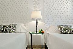detail of the beautiful and original white headboards and bedside table in the second bedroom