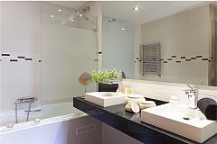 master ensuite bath with jetted bathtub and separate shower cabin in this LaMimosa apartment rental in Barcelona Eixample next to Passeig de Gràcia 