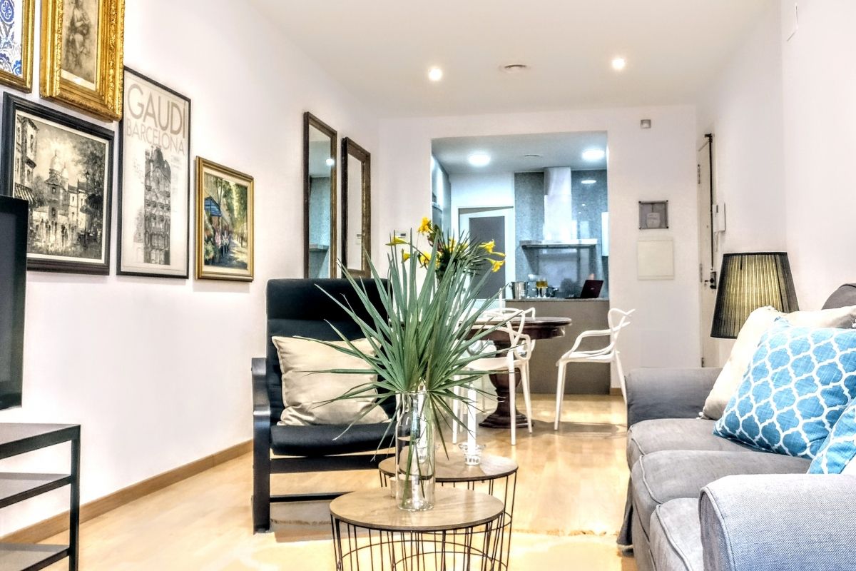 a comfortable sofa, two relaxing armchairs and a huge plasma screen TV, create the living areain this monthly rental in Barcelona