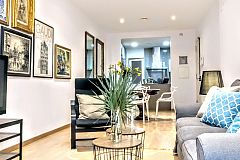 a comfortable sofa, two relaxing armchairs and a huge plasma screen TV, create the living areain this monthly rental in Barcelona