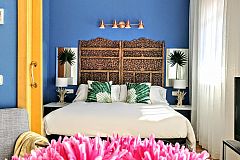 the amazing bedroom with palm leaves and night lamps, emerging from a bouquet of pale trunks.
