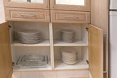 detail of the cabinets in the kitchen with all the chinaware and glassware and cutlery that you may need during your stay